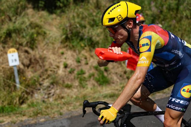 Lidl - Trek team's Spanish rider Juan Ayuso douses himself with water to cool down during the 10th stage of the 113th edition of the Tour de France cycling race, 166,6 km between Aurillac and Le Lioran in the Massif Central, on July 14, 2026. (Photo by Anne-Christine POUJOULAT / AFP)