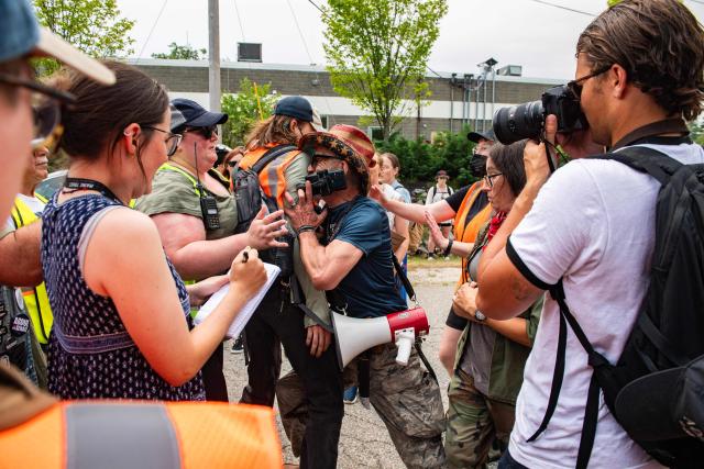 A man armed with a gun and a knife confronts demonstrators holding a protest outside of the Immigration and Customs Enforcement (ICE) field office in Scarborough, Maine, on July 14, 2026. A US immigration officer on July 13, fatally shot a man identified by rights groups as a 26-year-old Colombian, an incident likely to fuel criticism of President Donald Trump's deportation drive. The shooting happened in Biddeford, a town of 22,000 people in the northern state of Maine, and comes a week after an Immigration and Customs Enforcement (ICE) agent shot dead a Mexican man in Texas. (Photo by JOSEPH PREZIOSO / AFP)