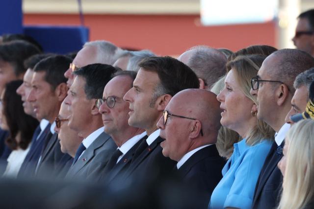 France's President Emmanuel Macron (C) sings the French national anthem next to Socialistes et Apparentes' MP Francois Hollande (centre R), Mayor of Nice Eric Ciotti (3R), President of the French National Assembly Yael Braun-Pivet (2R) and France's Interior Minister Laurent Nunez during a ceremony marking the 10th anniversary of an attack that killed 86 people and injured more than 400 in Nice, on the French riviera city of Nice on July 14, 2026. A solemn march, an interfaith ceremony, a military parade and a memorial service presided over by French President are on the programme for the commemorations marking the 10th anniversary of the attack on the Promenade des Anglais in Nice, as announced by the city council on July 1, 2026. On July 14, 2016, Mohamed Lahouaiej-Bouhlel, a Tunisian national, drove a 19-tonne lorry for nearly 2 km into the crowd that had just been watching the fireworks, killing 86 people and injuring more than 400 before he was shot dead. (Photo by Valery HACHE / AFP)