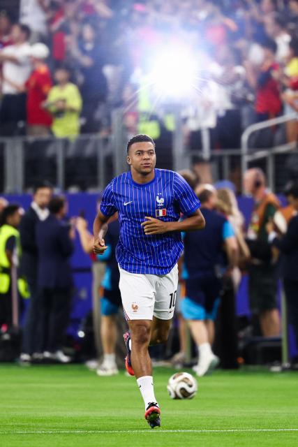 France's forward #10 Kylian Mbappe warms up ahead of the 2026 World Cup football tournament semi-final match between France and Spain at the Dallas Stadium in Arlington on July 14, 2026.  (Photo by FRANCK FIFE / AFP)