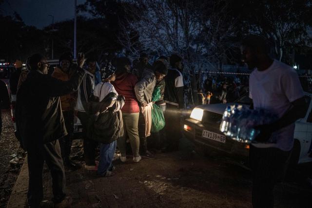 Malawian migrants gather in front of their Consulate in Johannesburg, on July 14, 2026 ahead of their repatriation towards Malawi. Several thousands more foreign nationals clamoured to leave South Africa on July 3, after a push that has already seen around 35,000 go home. The exodus began weeks ago as fringe groups began demanding all illegal migrants leave by June 30, in a campaign that saw violent protests and clashes. (Photo by MARCO LONGARI / AFP)
