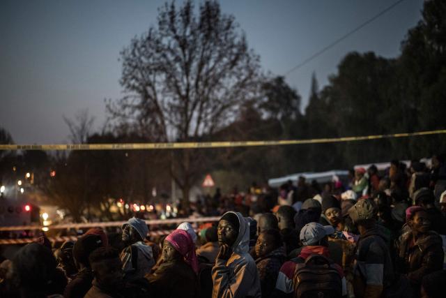 TOPSHOT - Malawian migrants gather in front of their Consulate in Johannesburg, on July 14, 2026 ahead of their repatriation towards Malawi. Several thousands more foreign nationals clamoured to leave South Africa on July 3, after a push that has already seen around 35,000 go home. The exodus began weeks ago as fringe groups began demanding all illegal migrants leave by June 30, in a campaign that saw violent protests and clashes. (Photo by MARCO LONGARI / AFP)