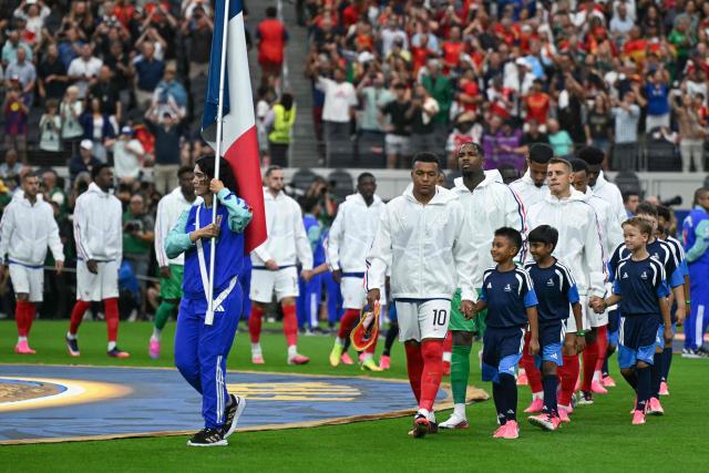 France's forward and captain #10 Kylian Mbappe (CR) leads France's players onto the pitch ahead of the 2026 World Cup football tournament semi-final match between France and Spain at the Dallas Stadium in Arlington on July 14, 2026.  (Photo by RONALDO SCHEMIDT / AFP)