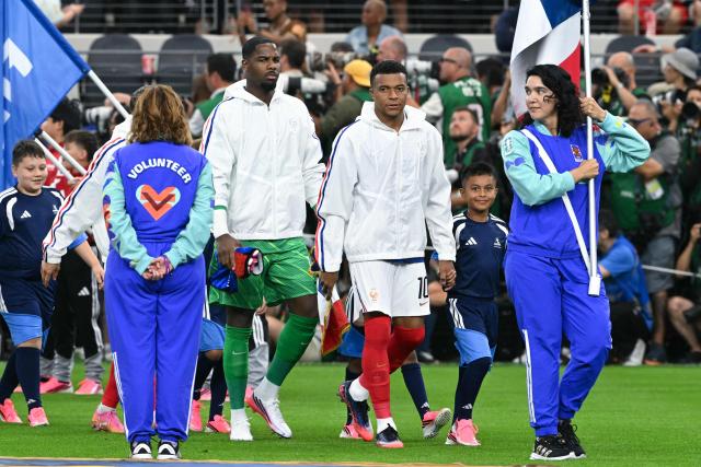 France's forward and captain #10 Kylian Mbappe (CR) leads France's players onto the pitch ahead of the 2026 World Cup football tournament semi-final match between France and Spain at the Dallas Stadium in Arlington on July 14, 2026.  (Photo by RONALDO SCHEMIDT / AFP)