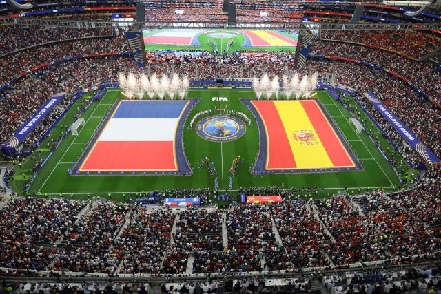 Spain and France's players stand for their national anthem ahead the 2026 World Cup football tournament semi-final match between France and Spain at the Dallas Stadium in Arlington on July 14, 2026.  (Photo by Odd ANDERSEN / AFP)