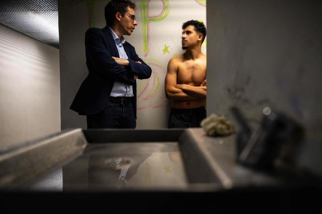 La France Insoumise MP Hadrien Clouet talks with a detainee in a cell at the Administrative Detention Centre (CRA) during a parliamentary visit, in Cornebarieu, southwestern France, on July 14, 2026. (Photo by Lionel BONAVENTURE / AFP)