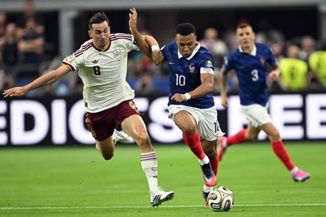 France's forward #10 Kylian Mbappe (R) fights for the ball with Spain's midfielder #08 Fabian Ruiz during the 2026 World Cup football tournament semi-final match between France and Spain at the Dallas Stadium in Arlington on July 14, 2026.  (Photo by MAURO PIMENTEL / AFP)
