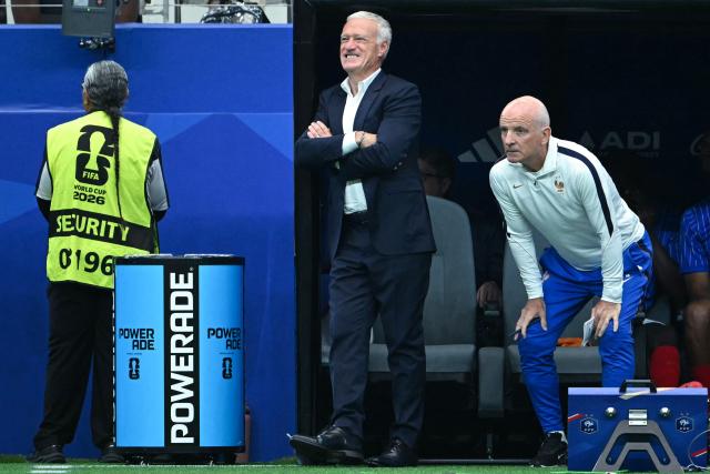 France's head coach Didier Deschamps (C) and France's assistant coach Guy Stephan (R) react in the techinal area during the 2026 World Cup football tournament semi-final match between France and Spain at the Dallas Stadium in Arlington on July 14, 2026.  (Photo by RONALDO SCHEMIDT / AFP)