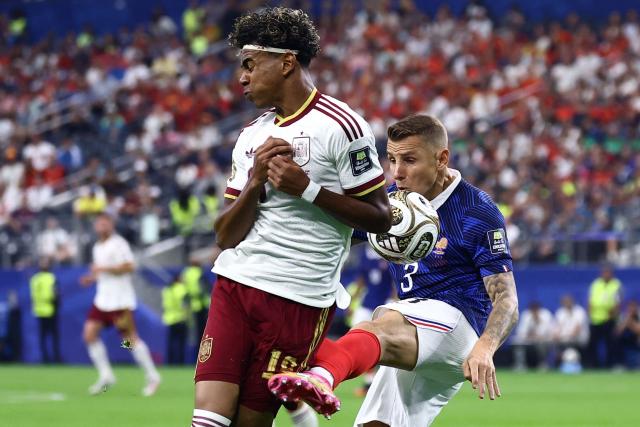 France's defender #03 Lucas Digne fouls Spain's forward #19 Lamine Yamal during the 2026 World Cup football tournament semi-final match between France and Spain at the Dallas Stadium in Arlington on July 14, 2026.  (Photo by CHARLY TRIBALLEAU / AFP)