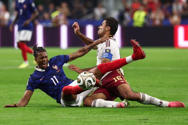 France's forward #11 Michael Olise and Spain's midfielder #16 Rodri falls on the field as they fight for the ball during the 2026 World Cup football tournament semi-final match between France and Spain at the Dallas Stadium in Arlington on July 14, 2026.  (Photo by FRANCK FIFE / AFP)