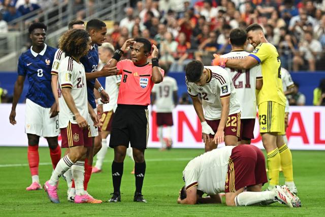 France's defender #26 Maxence Lacroix (3rd-L) talks to Salvadoran referee Ivan Barton after Spain players prevent a goal during the 2026 World Cup football tournament semi-final match between France and Spain at the Dallas Stadium in Arlington on July 14, 2026.  (Photo by Paul ELLIS / AFP)