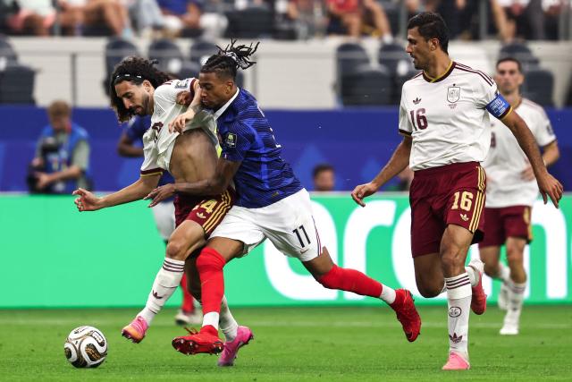 Spain's defender #24 Marc Cucurella and France's forward #11 Michael Olise fight for the ball past Spain's midfielder #16 Rodri during the 2026 World Cup football tournament semi-final match between France and Spain at the Dallas Stadium in Arlington on July 14, 2026.  (Photo by FRANCK FIFE / AFP)