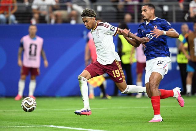 Spain's forward #19 Lamine Yamal (L) and France's defender #26 Maxence Lacroix fight for the ball during the 2026 World Cup football tournament semi-final match between France and Spain at the Dallas Stadium in Arlington on July 14, 2026.  (Photo by MAURO PIMENTEL / AFP)