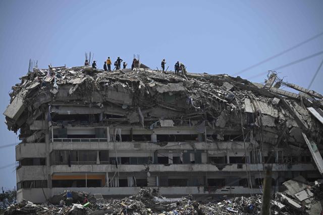 Rescuers and volunteers stand ato a collapsed building in Catia La Mar, La Guaira state, Venezuela, on July 14, 2026, following twin earthquakes that struck the region. The death toll from the deadly earthquakes that hit Venezuela on June 14 has surpassed 4,700, while almost 17,000 people have been injured, an official report released on July 14 stated. (Photo by Federico PARRA / AFP)