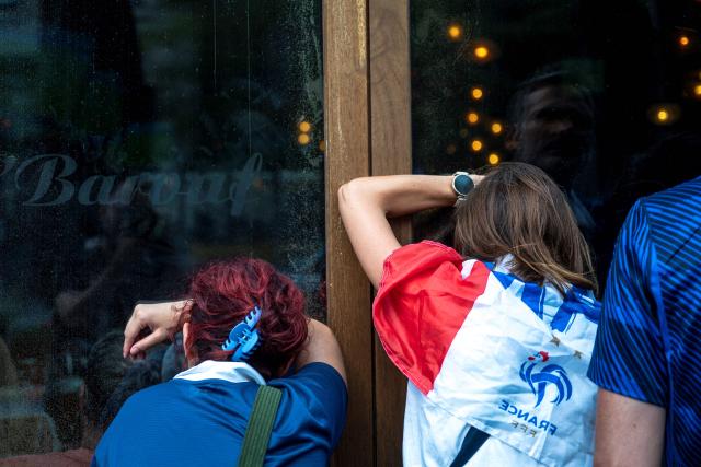 French fans watch the World Cup semi-final game between France and Spain through the window of a bar in Montreal, Quebec, on July 14, 2026. (Photo by ANDREJ IVANOV / AFP)