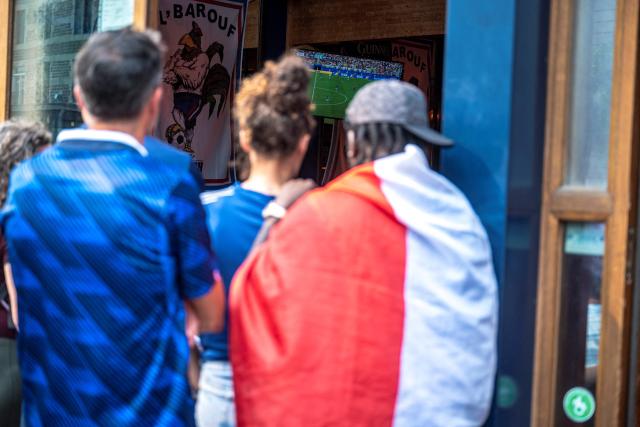 French fans watch the World Cup semi-final game between France and Spain through the window of a bar in Montreal, Quebec, on July 14, 2026. (Photo by ANDREJ IVANOV / AFP)