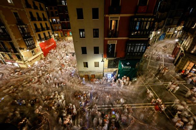 Revellers leave the streets after ending of the San Fermin festival in Pamplona, Spain early July 15, 2026. Thousands of people attend the week-long festival and its famous "encierros" or bull runs. Every day at 8:00 a.m., bulls are released through the narrow streets of the old town over an 850-meter course while runners ahead of them try to stay close without falling over or being gored. (Photo by ANDER GILLENEA / AFP)