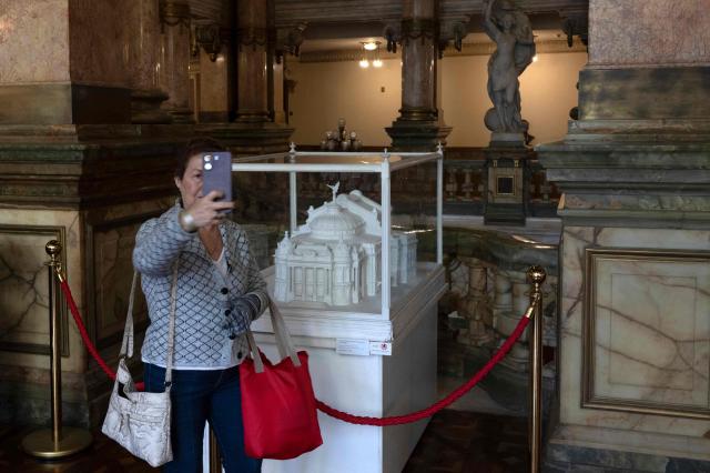 A visitor poses for a selfie while taking part in a guided tour at the Theatro Municipal do Rio de Janeiro (Rio de Janeiro's Municipal Theater) during celebrations marking its 117th anniversary with a series of events open to the public, on July 14, 2026, in Rio de Janeiro, Brazil. (Photo by Pablo PORCIUNCULA / AFP)
