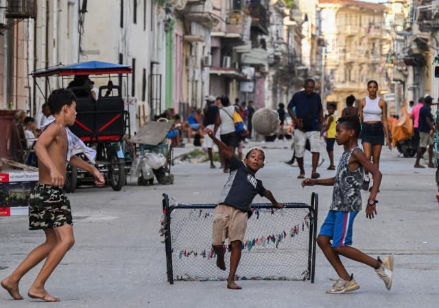 Children play football in the street in Havana during a general blackout on July 14, 2026. Cuba's power grid failed for the third time in less than 10 days, sparking another nationwide blackout, the national electricity company said. (Photo by YAMIL LAGE / AFP)