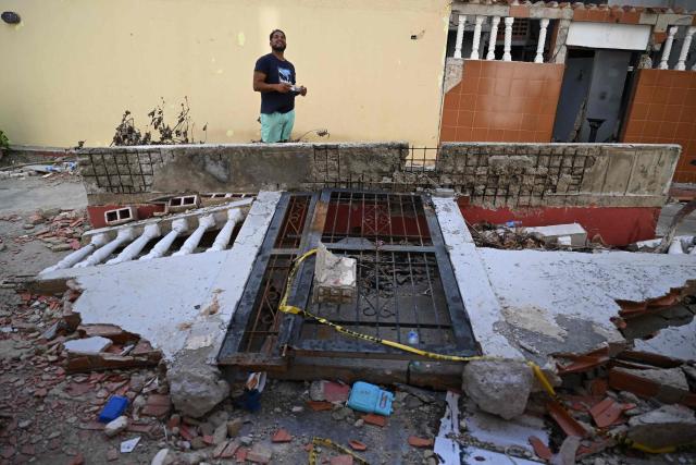 Venezuelan barber Ramon Gonzalez, 42, shows the place where he used to live, during an interview in Mare Abajo, La Guaira state, Venezuela, on July 14, 2026. The death toll from the deadly earthquakes that hit Venezuela on June 24 has surpassed 4,700, while almost 17,000 people have been injured, an official report released on July 14 stated. (Photo by Raul ARBOLEDA / AFP)