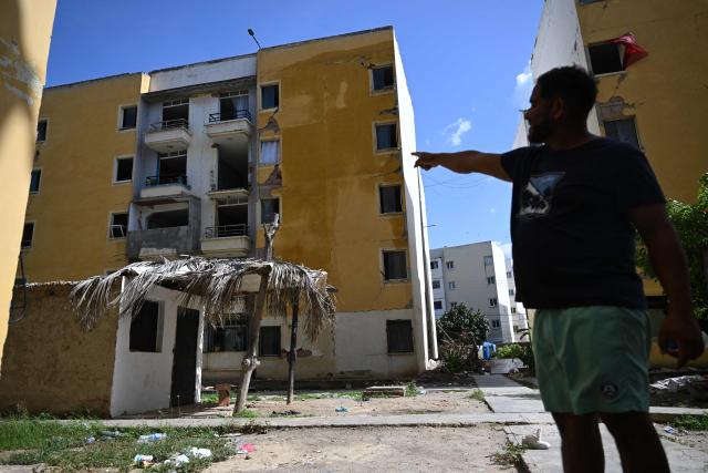 Venezuelan barber Ramon Gonzalez, 42, shows the place where he used to live, during an interview in Mare Abajo, La Guaira state, Venezuela, on July 14, 2026. The death toll from the deadly earthquakes that hit Venezuela on June 24 has surpassed 4,700, while almost 17,000 people have been injured, an official report released on July 14 stated. (Photo by Raul ARBOLEDA / AFP)