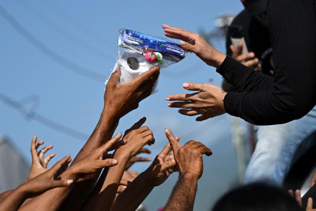 People displaced after the twin earthquakes receive hygiene kits in Mare Abajo, La Guaira state, Venezuela, on July 14, 2026. The death toll from the deadly earthquakes that hit Venezuela on June 24 has surpassed 4,700, while almost 17,000 people have been injured, an official report released on July 14 stated. (Photo by Raul ARBOLEDA / AFP)