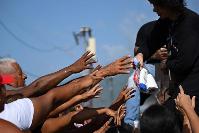 People displaced after the twin earthquakes receive hygiene kits in Mare Abajo, La Guaira state, Venezuela, on July 14, 2026. The death toll from the deadly earthquakes that hit Venezuela on June 24 has surpassed 4,700, while almost 17,000 people have been injured, an official report released on July 14 stated. (Photo by Raul ARBOLEDA / AFP)