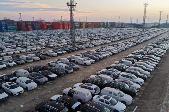 Chinese-made Volvo cars are seen alongside containers before being loaded onto ships for export at the port in Nanjing, in China’s eastern Jiangsu province on July 15, 2026. (Photo by CN-STR / AFP) / China OUT