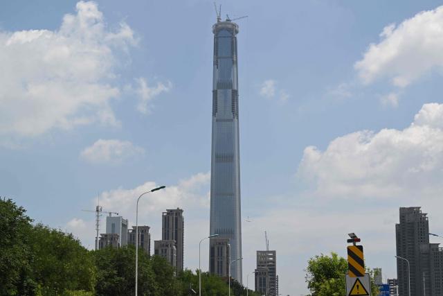 A view of the under-construction Goldin Finance 117 skyscraper is seen in Tianjin on July 14, 2026. The world's tallest unoccupied skyscraper was meant to boast a rooftop swimming pool and a luxury hotel once completed, but instead it has stood deserted in the Chinese port city of Tianjin for years. Work on the soaring Goldin Finance 117 began in 2008, but construction stalled as its developer fell into debt, and the tower remains unfinished 18 years on. (Photo by ADEK BERRY / AFP)