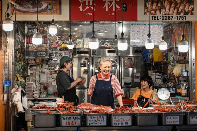 Food vendors wait for customers at Gwangjang Market in Seoul on July 15, 2026. (Photo by JADE GAO / AFP)