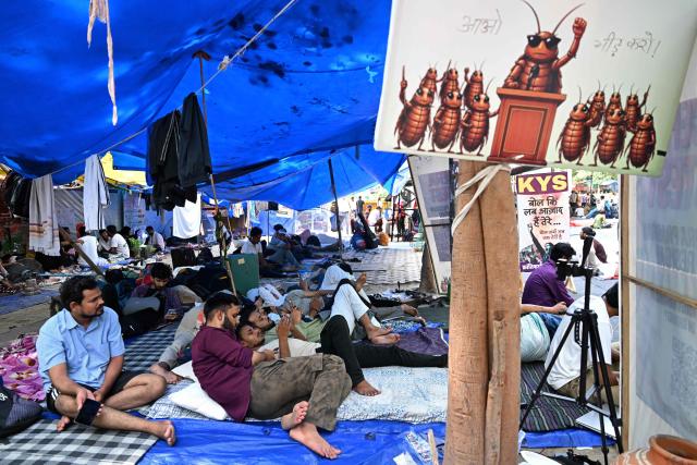 Cockroach Janta Party (CJP) supporters take part in a hunger strike during a sit-in protest in New Delhi on July 15, 2026, to demand the resignation of India’s Education Minister Dharmendra Pradhan over alleged examination irregularities. (Photo by Arun SANKAR / AFP)