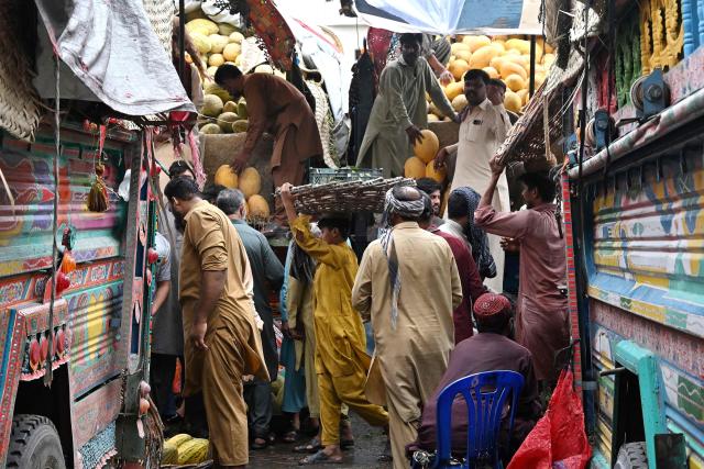 Traders wait for customers at a wholesale fruit market in Lahore on July 15, 2026. (Photo by Arif ALI / AFP)