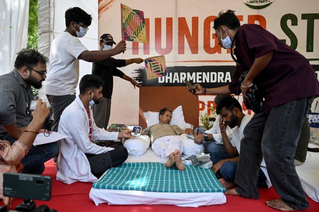 Cockroach Janta Party (CJP) founder Abhijeet Dipke (2R) reacts as doctors check activist Sonam Wangchuk’s vital signs during his hunger strike in New Delhi on July 15, 2026, demanding the resignation of India’s Education Minister Dharmendra Pradhan over alleged examination irregularities. (Photo by Arun SANKAR / AFP)