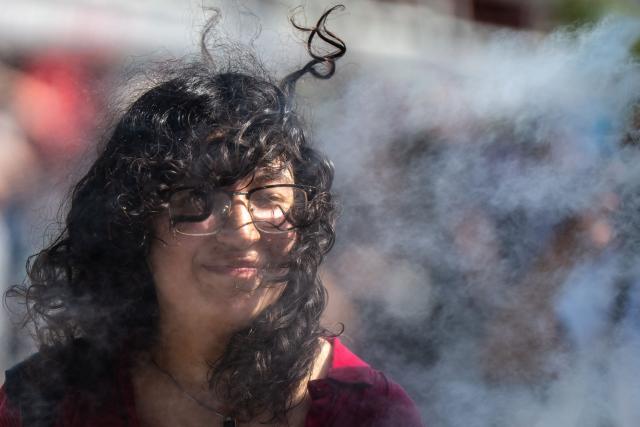 A tourist reacts next to the mist from cooling sprayers at the Sensoji Temple on a hot day in Tokyo on July 15, 2026. (Photo by Philip FONG / AFP)