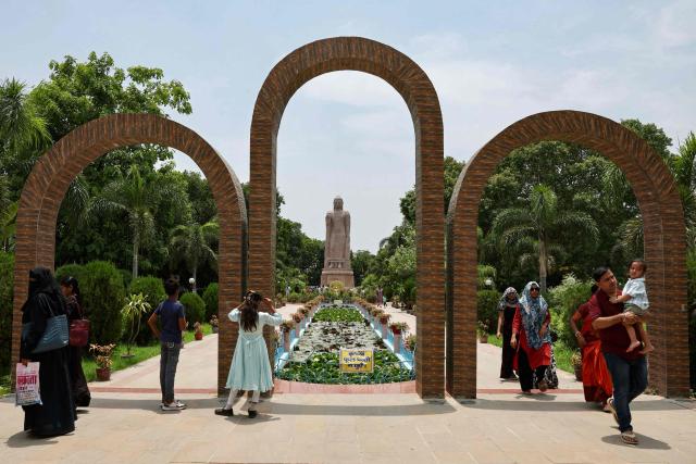 Tourists walk past a Buddha statue at the Wat Thai Temple in Sarnath, on the outskirts of Varanasi on July 15, 2026. (Photo by Niharika KULKARNI / AFP)