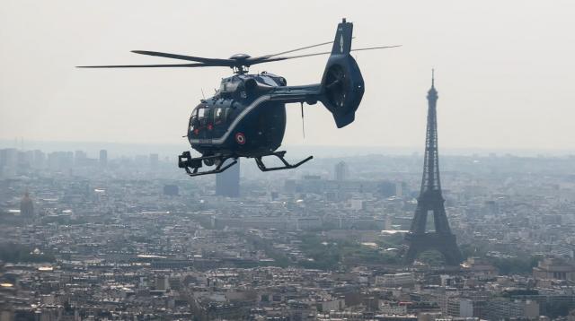 This frame grab from an AFP TV video shows the new helicopter H145 D3 of the French gendarmerie flies over Paris and by The Eiffel Tower during the annual Bastille Day military parade, on July 14, 2026. The H145 D3, has been in service for the past five months and its performance is enhanced by innovative technological features such as optronics sensors, reinforced ballistic protection and a secure data transmission system. Two helicopters of this type were funded by the British via the Sandhurst Fund, as part of the Sandhurst Cooperation Treaty between France and the United Kingdom, aimed at curbing illegal crossings of the English Channel. This treaty was signed on January 18, 2018 during the 35th Franco-British summit. A second helicopter has been delivered to Amiens. Four more are due to be delivered by 2028. (Photo by Benoît DUCROCQ / AFP)