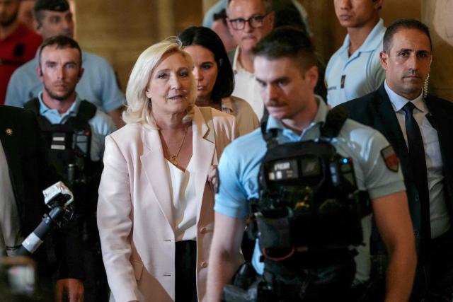(FILES) President of Rassemblement National parliamentary group Marine Le Pen (C-L) leaves after the verdict in the appeal trial of RN former or actual members on charges of embezzlement of European public funds in a case of alleged European Parliament fake jobs at Paris Court of Appeal on July 7, 2026. The Office of the Prosecutor General at the Paris Court of Appeal announced on July 15, 2026 that it had decided not to file an appeal with the Court of Cassation in the case involving the French far-right party, then Front National (FN), now Rassemblement National (RN), parliamentary assistants to Members of the European Parliament, "following a thorough review of the judgment handed down on July 7." Marine Le Pen, for her part, said last week that she would appeal to the Court of Cassation. Her appeal therefore suspends the enforcement of her one-year prison sentence, which was to be served under home detention with electronic monitoring (an ankle bracelet), pending the court's ruling. (Photo by Dimitar DILKOFF / AFP)