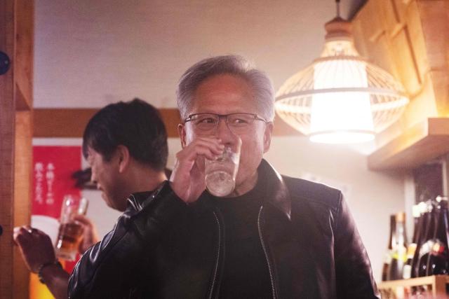 Nvidia CEO Jensen Huang (C) drinks after giving a toast to his guests inside a restaurant in Tokyo on July 15, 2026. (Photo by Andrew CABALLERO-REYNOLDS / AFP)