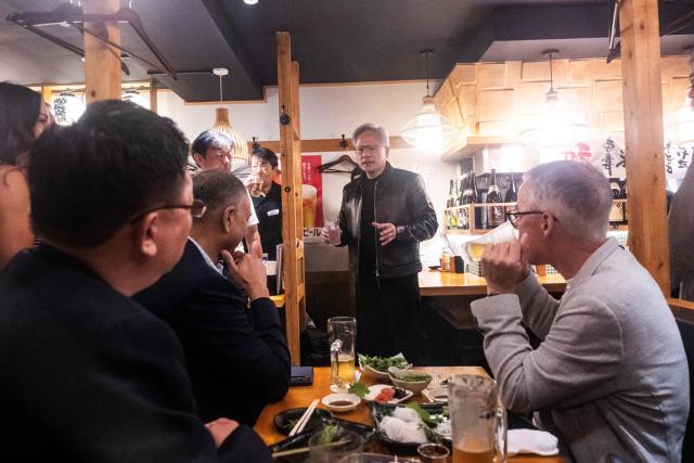 Nvidia CEO Jensen Huang (C) speaks after giving a toast to his guests inside a restaurant in Tokyo on July 15, 2026. (Photo by Andrew CABALLERO-REYNOLDS / AFP)