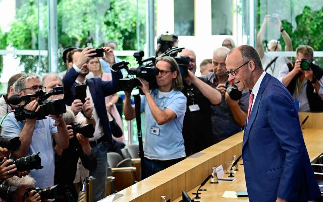 German Chancellor Friedrich Merz faces cameramen and photographers as he arrives to address journalists during his summer press conference in Berlin, Germany, on July 15, 2026. (Photo by Tobias SCHWARZ / AFP)
