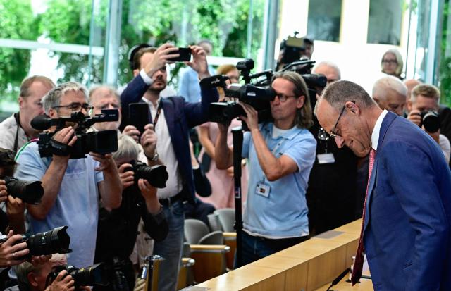 German Chancellor Friedrich Merz faces cameramen and photographers as he arrives to address journalists during his summer press conference in Berlin, Germany, on July 15, 2026. (Photo by Tobias SCHWARZ / AFP)