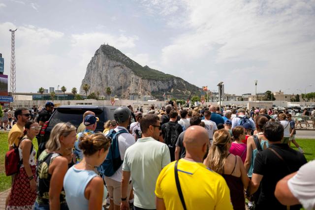People walk towards the border between Spain and the British overseas territory of Gibraltar at the  border crossing in La Linea de la Concepcion, southern Spain, on July 15, 2026. A new era began between Spain and the tiny British territory of Gibraltar on July 15, 2026, as border checks that have long been a source of tension and frustration were finally lifted after the signing of a post-Brexit deal in Brussels between the UK, Spain, Gibraltar and the EU. (Photo by JORGE GUERRERO / AFP)