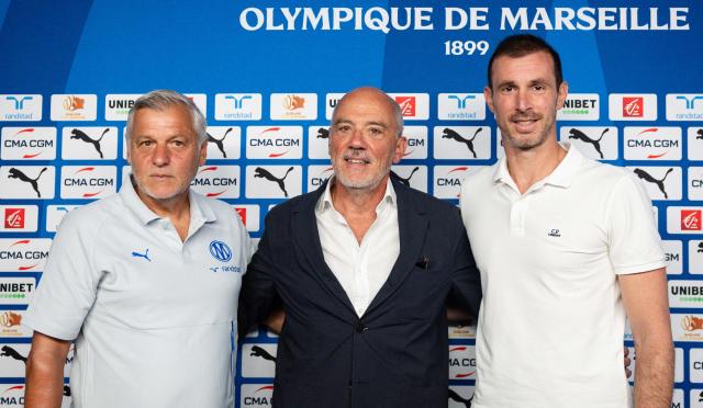 Marseille's new French head coach Bruno Genesio (L) and Marseille's new French football director Gregory Lorenzi (R) pose for pictures with Marseille's President Stephane Richard (C) during a press conference at the Olympique de Marseille (OM) Robert-Louis-Dreyfus training centre in Marseille, southern France on July 15, 2026 (Photo by CLEMENT MAHOUDEAU / AFP)