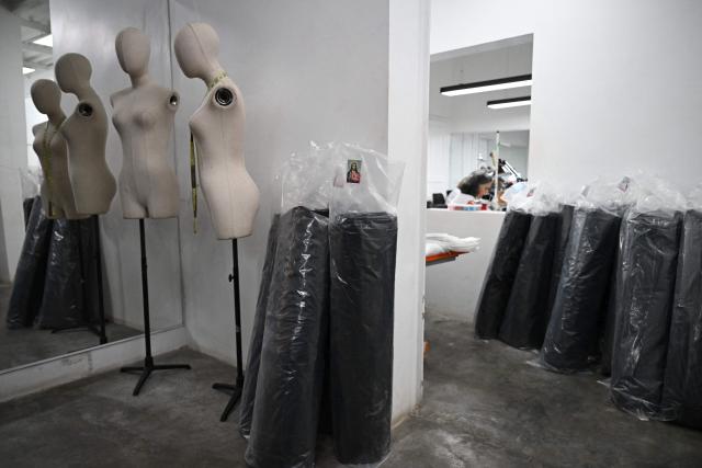 This image shows packs of rolls of body bags for the earthquakes victims, at the ByEfrainMogollon workshop in Maracay, state of Aragua, Venezuela, on July 13, 2026. At a fashion workshop in Venezuela, the sewing machines set aside the brightly coloured threads used to make elegant dresses to sew body bags, which the creative director decided to donate to rescue workers, volunteers and relatives recovering bodies from the buildings that collapsed following the twin earthquakes measuring 7.2 and 7.5. (Photo by Raul ARBOLEDA / AFP)