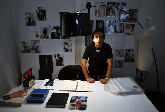 Venezuelan fashion designer Efrain Mogollon, 44, poses for a picture at his office in his workshop in Maracay, state of Aragua, Venezuela, on July 13, 2026. At a fashion workshop in Venezuela, the sewing machines set aside the brightly coloured threads used to make elegant dresses to sew body bags, which the creative director decided to donate to rescue workers, volunteers and relatives recovering bodies from the buildings that collapsed following the twin earthquakes measuring 7.2 and 7.5. (Photo by Raul ARBOLEDA / AFP)