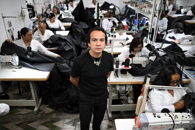 Venezuelan fashion designer Efrain Mogollon, 44, poses for a picture at his workshop in Maracay, state of Aragua, Venezuela, on July 13, 2026. At a fashion workshop in Venezuela, the sewing machines set aside the brightly coloured threads used to make elegant dresses to sew body bags, which the creative director decided to donate to rescue workers, volunteers and relatives recovering bodies from the buildings that collapsed following the twin earthquakes measuring 7.2 and 7.5. (Photo by Raul ARBOLEDA / AFP)