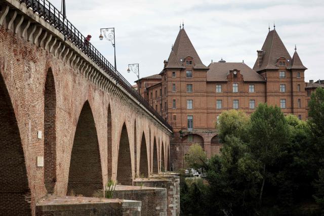 (FILES) This photograph shows the Ingres Bourdelle Museum and the Old Bridge in Montauban, southwestern France, on July 15, 2025. Until November 8, 2026, the exhibition “Ingres and Fashion” showcases, through more than 200 items – including paintings, drawings, textiles, accessories and documents – the painter’s unique focus on the finery and attire of his high-society models. The Ingres Bourdelle Museum in Montauban (Tarn-et-Garonne) follows the vision of Jean-Auguste-Dominique Ingres, the undisputed master of portraiture, in exploring the fashion and attire of his era, through a rich and varied exhibition in which paintings and costumes complement one another. (Photo by Valentine CHAPUIS / AFP)
