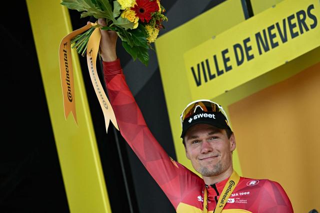 Uno-X Mobility team's Norwegian rider Soren Waerenskjold celebrates on the podium after winning the 11th stage of the 113th edition of the Tour de France cycling race, 161,3 km between Vichy and Nevers in central France, on July 15, 2026. (Photo by Loic VENANCE / AFP)