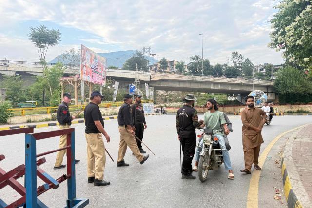 Police frisk people at a checkpoint in Muzaffarabad, the capital of Pakistan-administered Kashmir on July 15, 2026. Nine people were killed and a dozen wounded in renewed clashes between supporters of a banned protest group and security forces in Pakistan-administered Kashmir, an official said on July 15. (Photo by Sajjad QAYYUM / AFP)