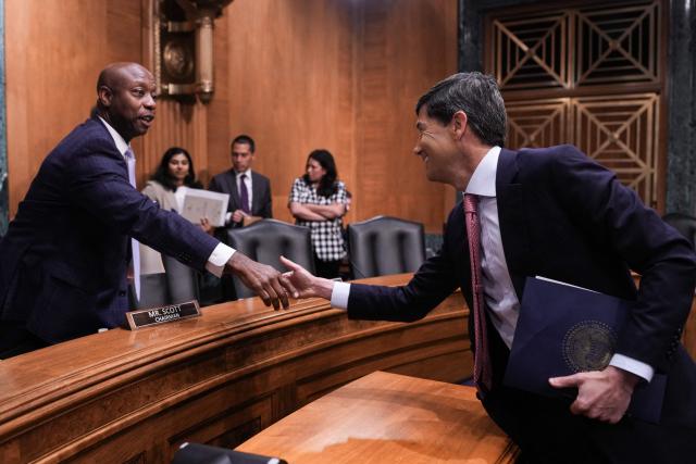 US Federal Reserve Chair Kevin Warsh (R) shakes hands with committee chairman Senator Tim Scott, Republican from South Carolina, at the end of a Senate Banking Committee hearing titled "The Semiannual Monetary Policy Report to the Congress" on Capitol Hill in Washington, DC, on July 15, 2026. (Photo by Ken Cedeno / AFP)